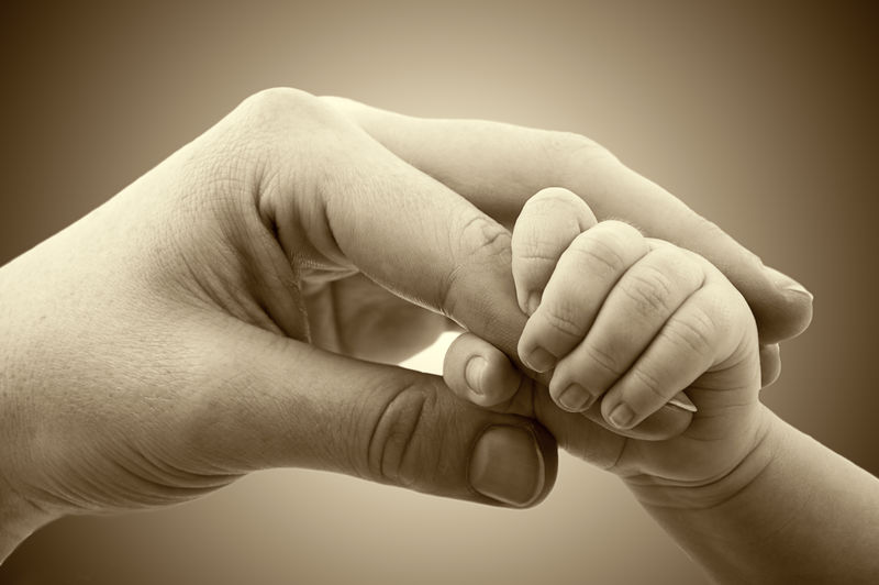 爱与家庭的概念-妈妈和宝宝的手的特写