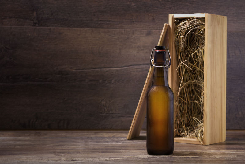 手工制作啤酒瓶模型-没有标签的啤酒瓶-木制礼品盒放在乡村桌子上