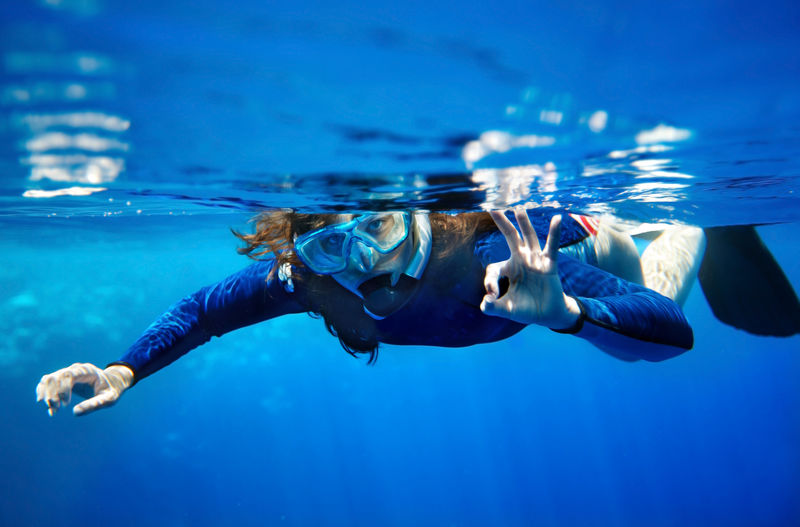 水下呼吸器潜水员女人在蓝水