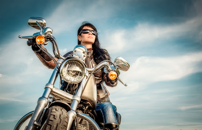 骑摩托车看日落时穿皮夹克的骑车女孩