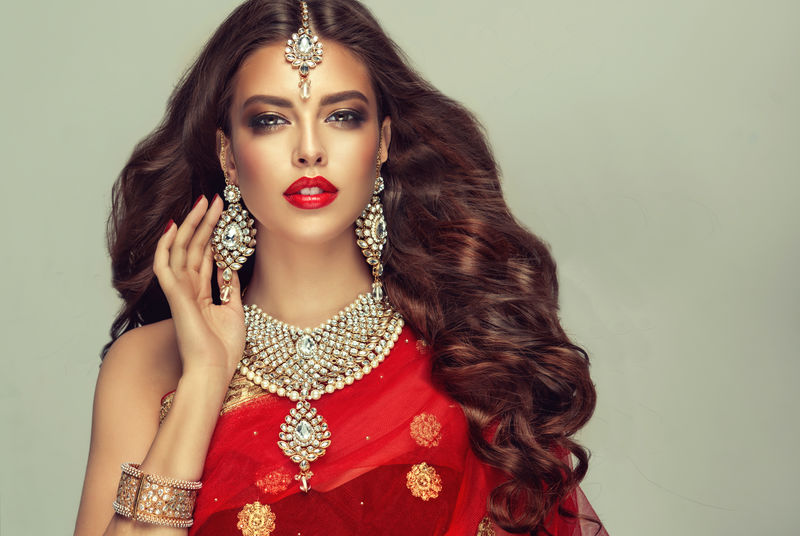 美丽的印度女孩的肖像年轻的印度教妇女模型与昆丹珠宝套装传统印度服装红色纱丽