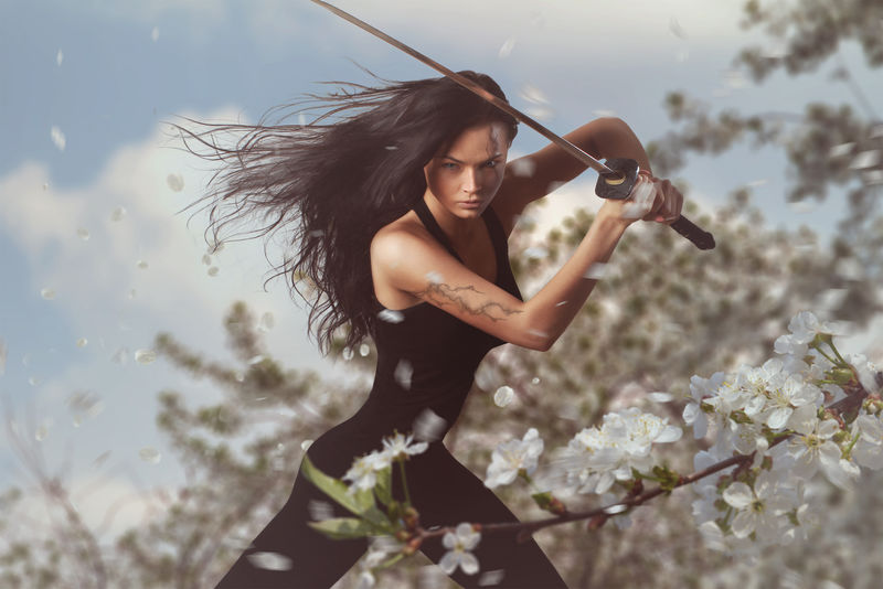 春花环境中美丽的黑发女人配卡塔纳剑