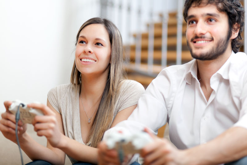 年轻夫妇在公寓里玩电子游戏