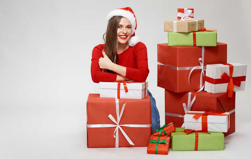 孤零零的全身圣诞画像-女人坐在地上-手里拿着一堆礼物