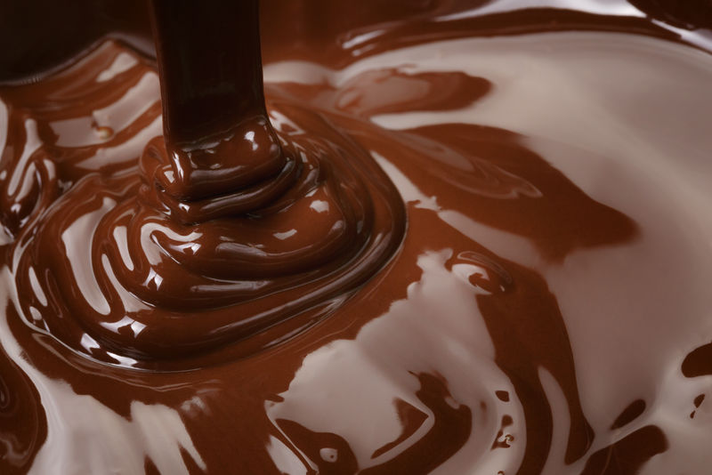 融化的黑巧克力流-糖果或巧克力准备的背景