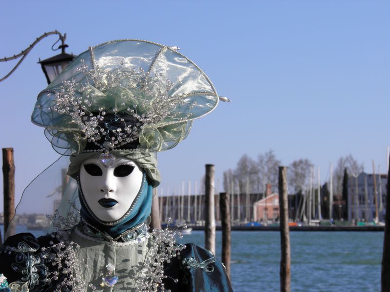 威尼斯的狂欢节服装-背景是蓝色的平底船