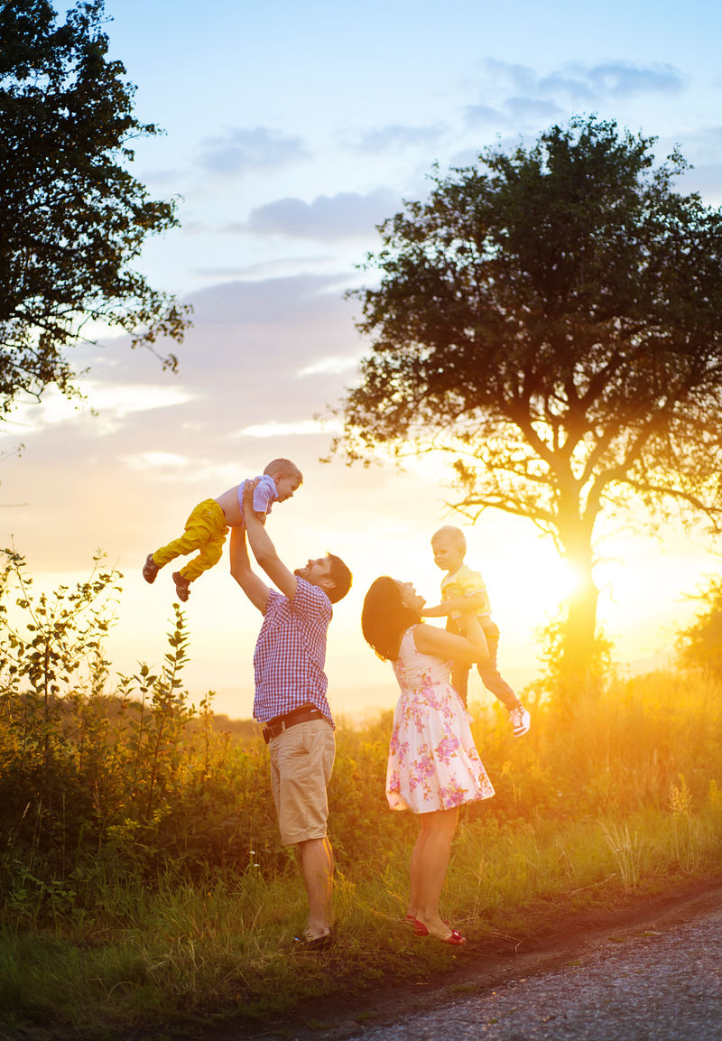 快乐的年轻家庭在绿色的大自然中共度时光