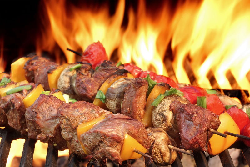 在热烤架上烤牛肉串-背景中的火焰