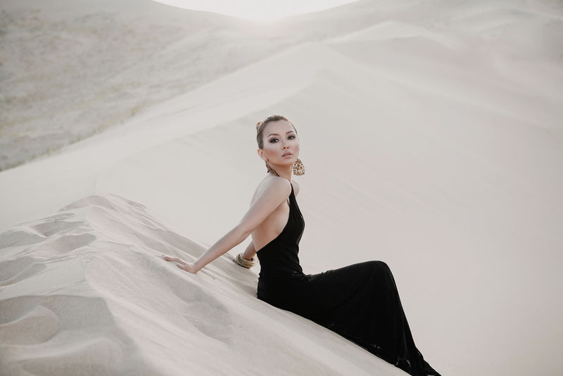 沙漠中美丽性感的亚洲女人的时尚照片
