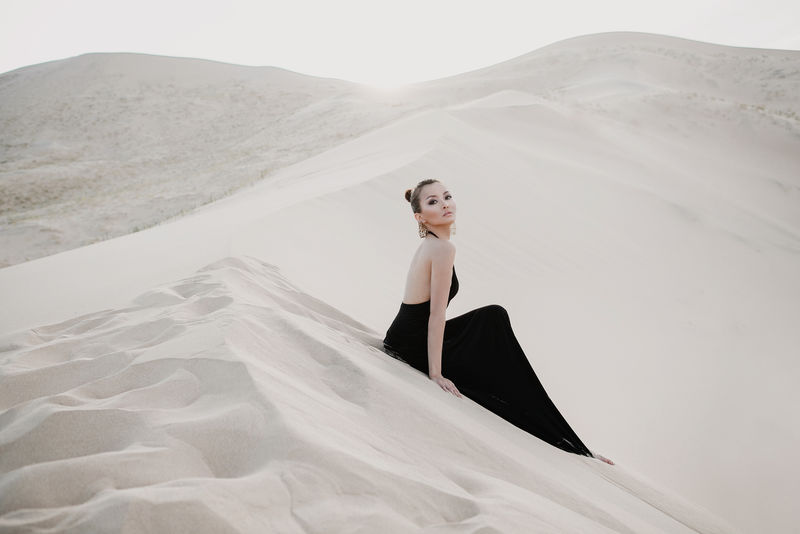 沙漠中美丽性感的亚洲女人的时尚摄影