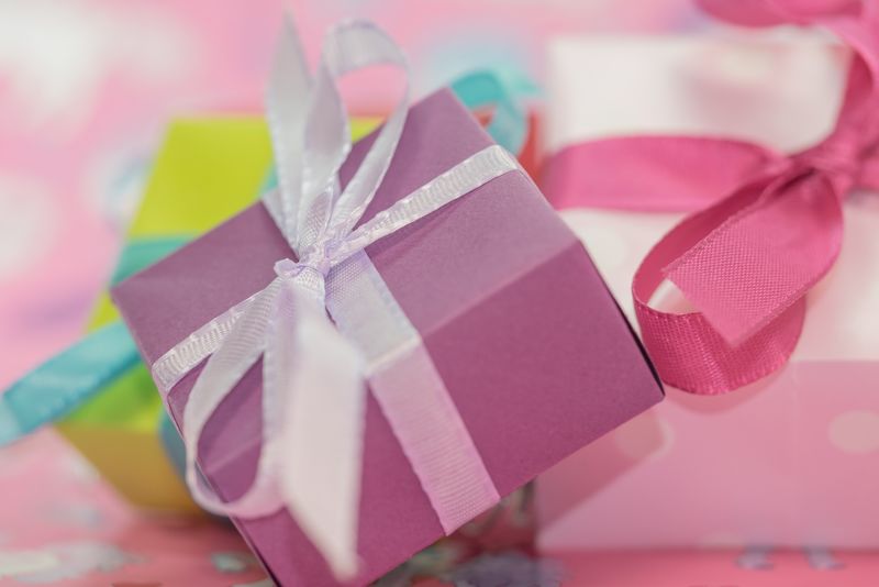 易碎的粉色郁金香和节日礼物-带浅粉色丝带