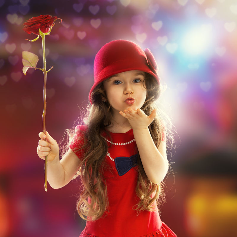 人-幸福观-穿着红玫瑰的快乐小女孩吻她的手