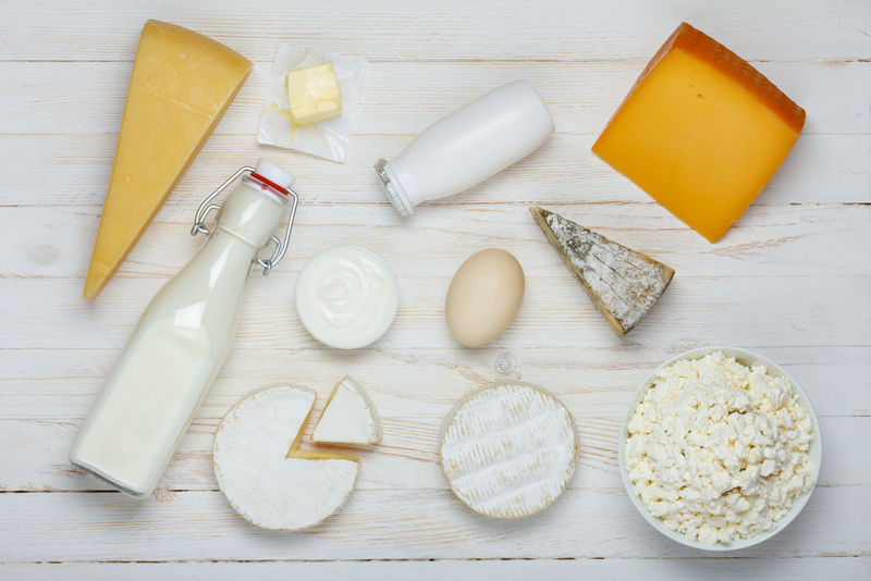 木制桌子上的乳制品分类-牛奶、奶酪、鸡蛋、酸奶、酸奶油、农家干酪和黄油