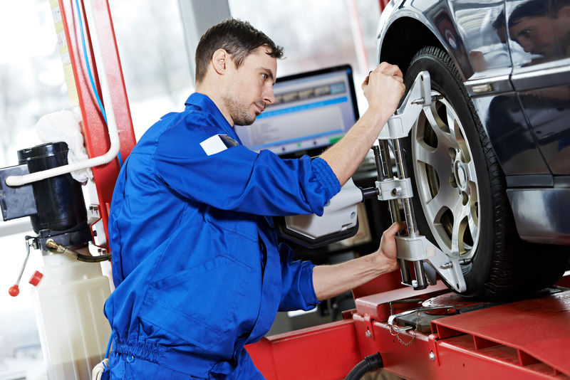 汽车修理工在修理站安装悬架调整和车轮定位期间的传感器