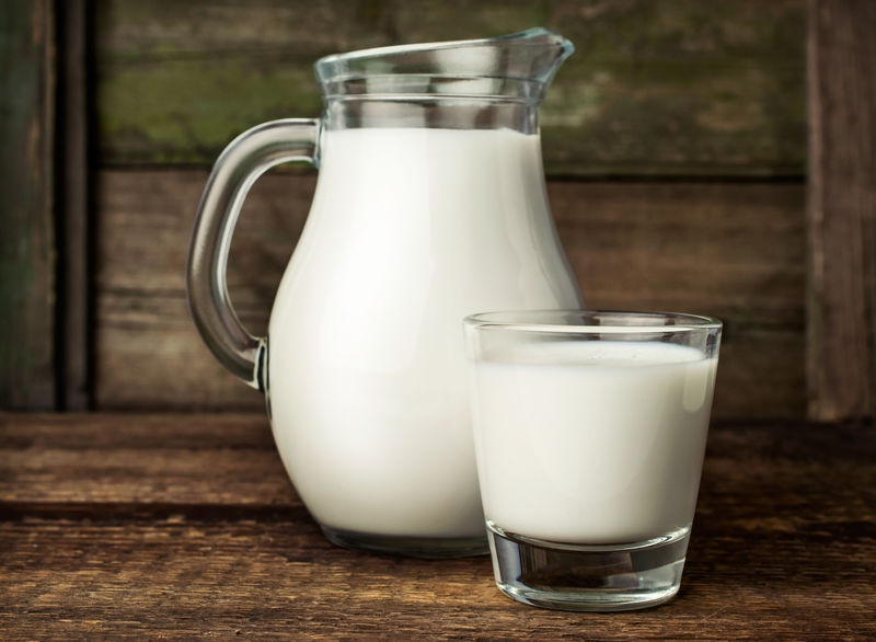 新鲜牛奶装在玻璃罐和玻璃杯中。