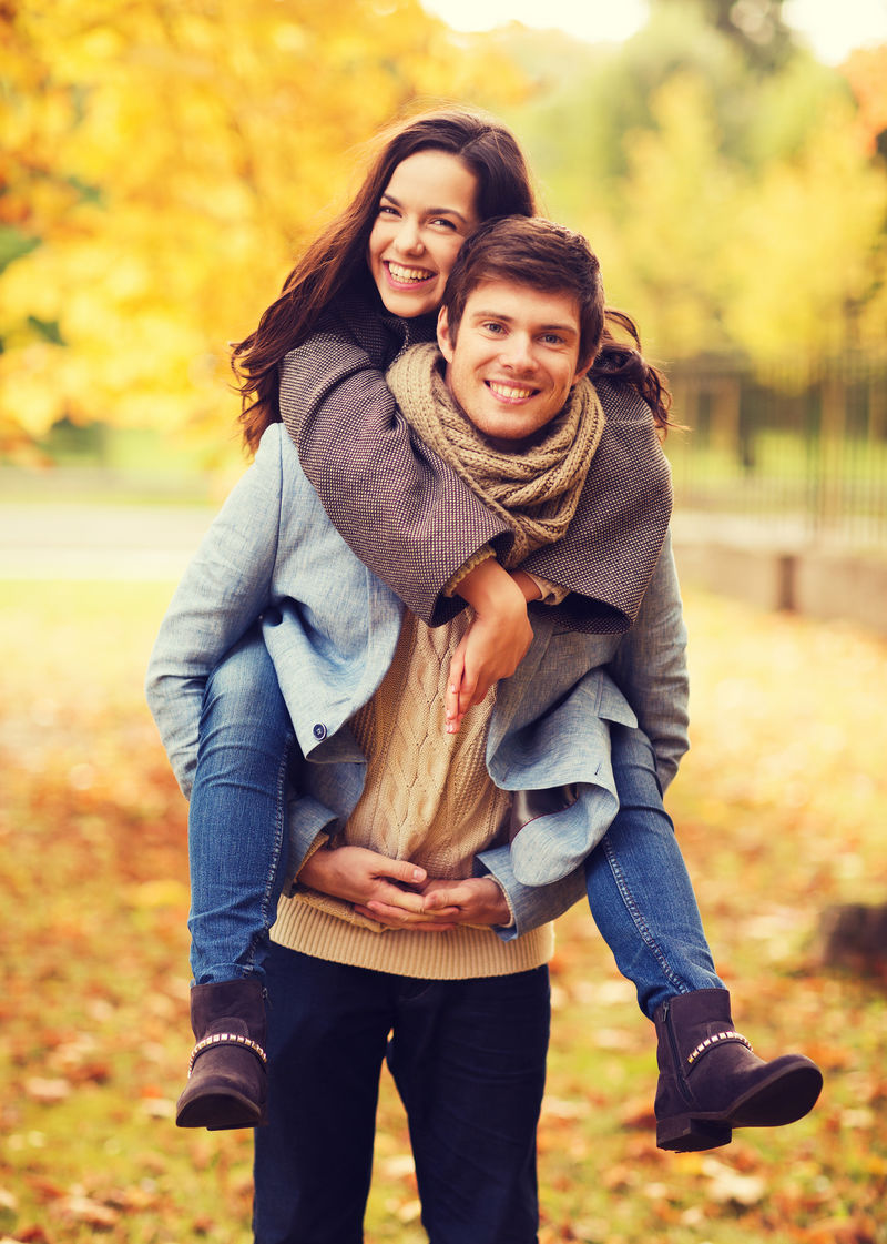 爱、关系、家庭和人的概念——秋园微笑的情侣拥抱