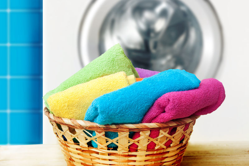 一堆彩色干净毛巾和洗衣机