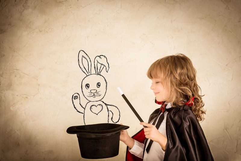 小魔术师拿着顶帽子-在肮脏的背景下画着兔子-专注于帽子