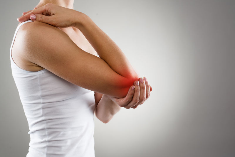 患慢性关节风湿病的妇女-肘部疼痛与治疗概念