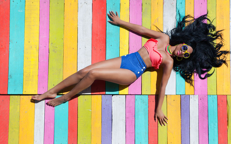 热带暑假时尚概念-非洲裔美国妇女在木码头背景