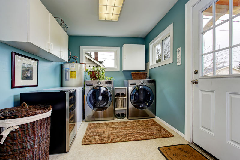淡蓝色的洗衣房-配有现代化的钢制电器和白色橱柜