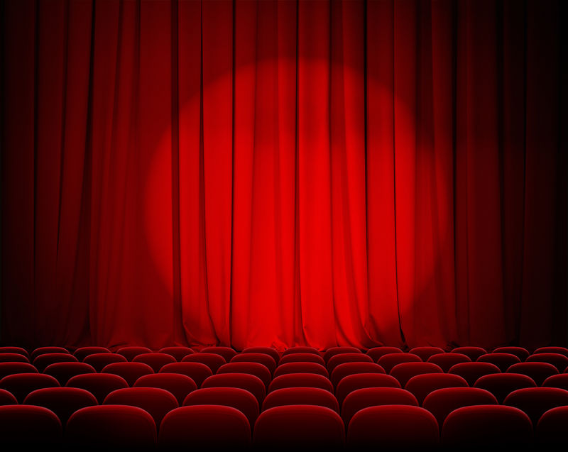 带有聚光灯和座位的封闭式剧院红色窗帘