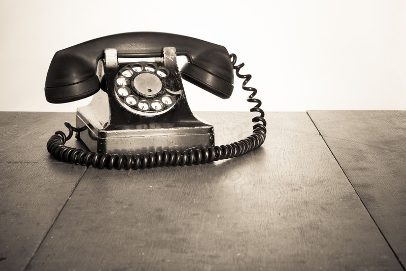 旧桌子上的老式电话-深褐色照片