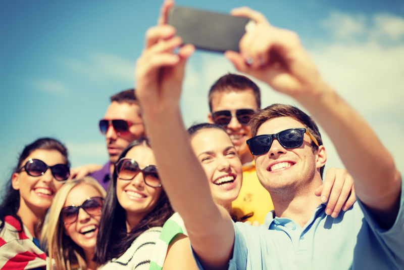 夏天-假期-假期和幸福概念的朋友采取selfie与智能手机组
