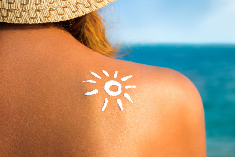 妇女在沙滩上晒太阳-以防晒、护肤、护肤的形式