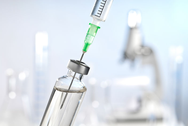 实验室场景前的注射器和疫苗