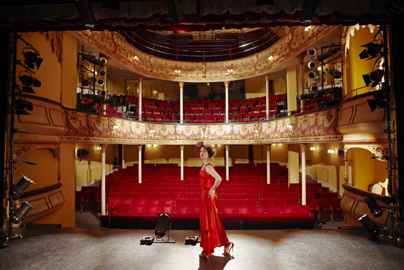 舞台上穿着红色长袍的漂亮女人。