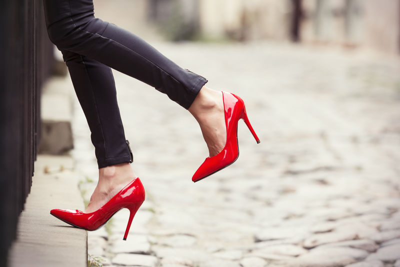 老妇人穿黑色皮裤子和红色高跟鞋