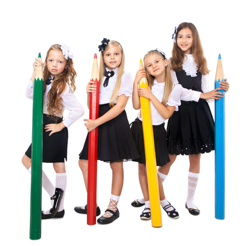 一群带着大彩色铅笔的微笑的女学生-被隔离在白色背景上-学校、时尚、友谊理念