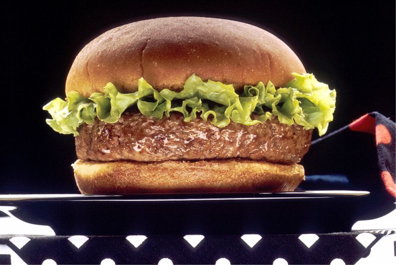 素食汉堡包-由茄子汉堡包、奶酪、洋葱、西红柿、奶酪和面包做成-在有纹理的黑板上