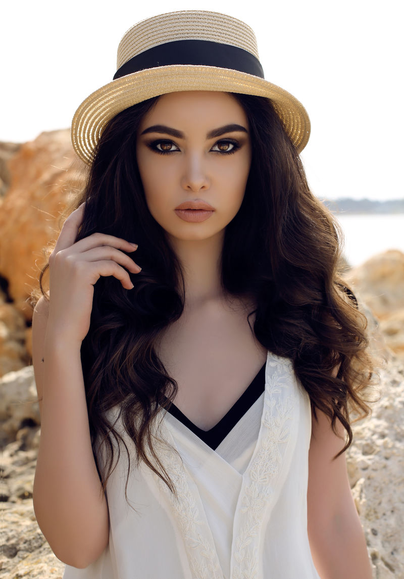 黑头发的漂亮女孩穿着休闲优雅的衣服和帽子