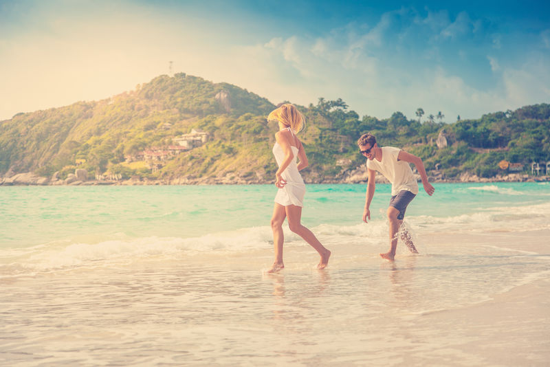 一对美丽的年轻夫妇在热带海边散步