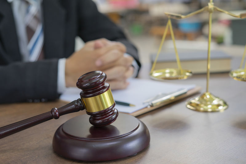 木桌上的木槌和律师或法官在法庭主题、司法和法律概念上达成一致