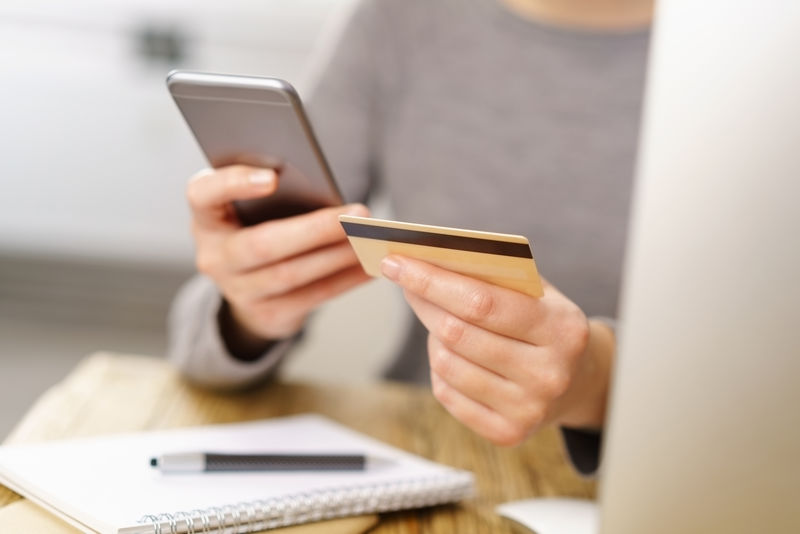 一个女人用手机支付她的信用卡细节