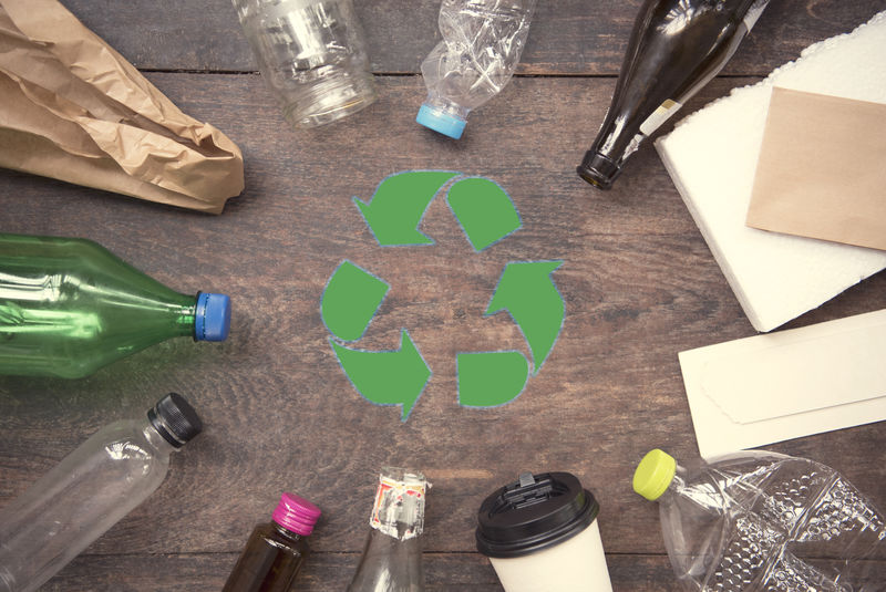 回收符号和塑料-纸张-玻璃木桌面背景顶视图-生态与拯救地球的理念