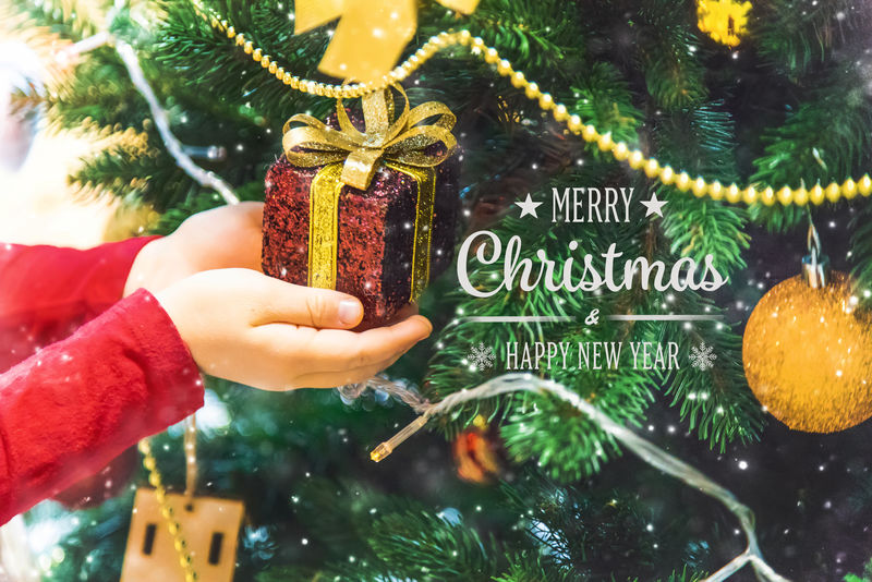 圣诞背景和手上有装饰品的孩子。新年。选择性聚焦。
