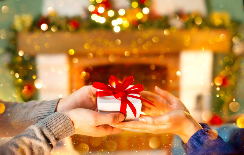 圣诞礼物在手-快乐的男人把圣诞和新年礼物盒送给家里的女人-家庭圣诞庆祝-拿着礼物盒的人-圣诞节装饰-关系