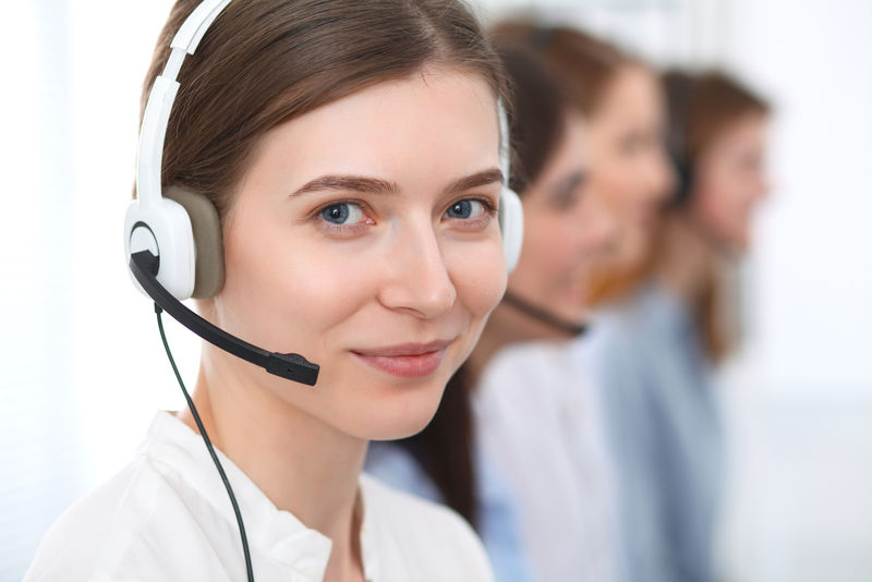 呼叫中心-美丽开朗的微笑接线员用耳机咨询客户-客户服务的经营理念