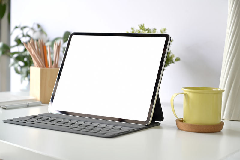 白色桌面上的模拟白屏平板电脑和智能键盘