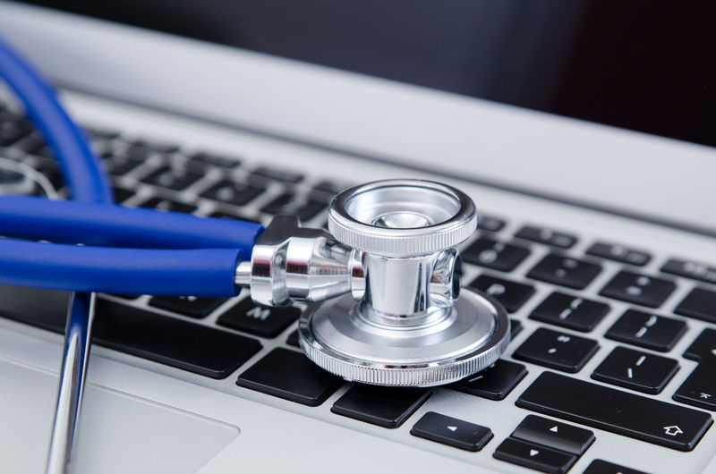 笔记本电脑键盘上听诊器的特写镜头-医疗保健与医疗理念