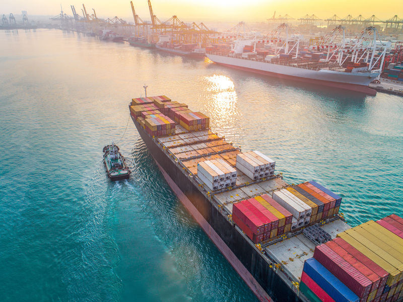 从空中俯瞰集装箱船舶到达主入口大门国际港口运输和物流系统服务全球海洋和陆地