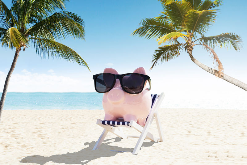 背着墨镜坐在躺椅上-在沙滩上享受假期