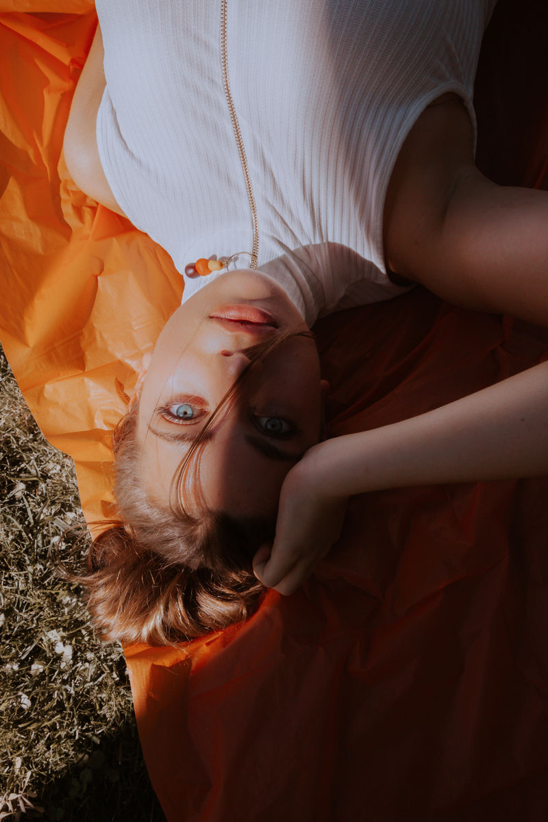 躺在橘色纺织品上的女人