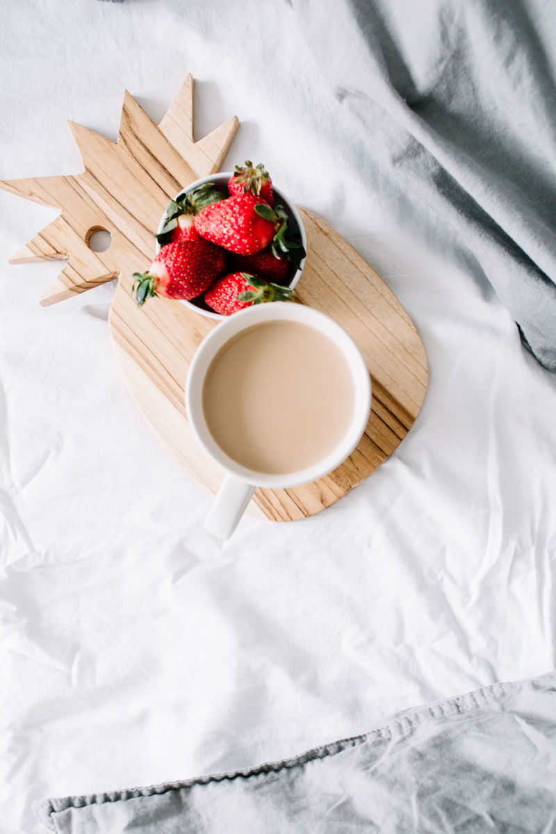 床上早餐-咖啡杯和草莓-亮灰色亚麻布-平放-俯视图