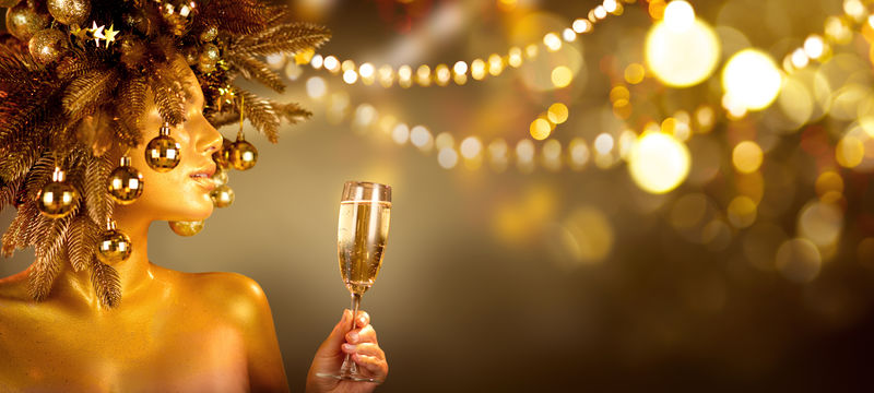 美丽迷人的金色圣诞女人用香槟庆祝-戴着用装饰品装饰的花环-派对上-喝着起泡酒-节日的背景光彩夺目-圣诞节-新年假期庆祝