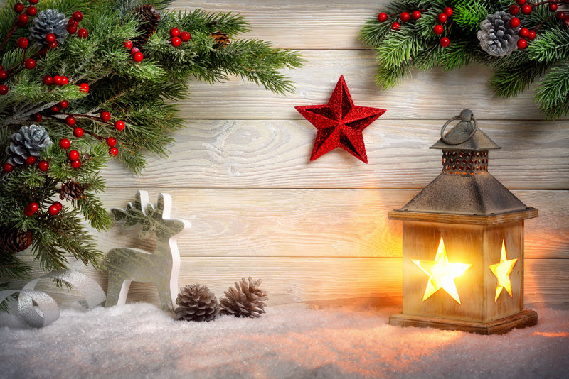 圣诞场景背景灯-冷杉枝-红星-驯鹿和雪在明亮的木板前与烛光